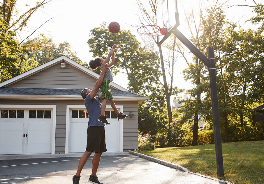People playing basketball in driveway